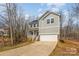 Charming home with gray siding, front porch, two-car garage, and a driveway leading up to the house at 418 Wintergreen Ct, Kings Mountain, NC 28086