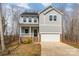 Charming two-story home featuring gray siding, front porch with white railing, and an attached two-car garage at 418 Wintergreen Ct, Kings Mountain, NC 28086