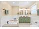Luxurious bathroom with a soaking tub, dual sinks, and elegant green cabinetry at 600 S Central Ave, Belmont, NC 28012