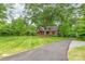 Charming brick home with a manicured lawn, mature trees, and an asphalt driveway at 600 S Central Ave, Belmont, NC 28012