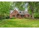 Charming brick home featuring a well-manicured lawn and mature trees at 600 S Central Ave, Belmont, NC 28012