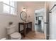 Bathroom featuring a wooden vanity, round mirror, and black fixtures at 7403 Grassy Ridge Rd, Denver, NC 28037