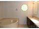 Bathroom featuring a vanity, bathtub, and unique window design, blending functionality with unique elements at 7597 Webbs Rd, Denver, NC 28037