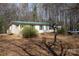Ranch style home, metal roof, mature trees on a large lot, with a pick-up truck in the driveway at 7597 Webbs Rd, Denver, NC 28037