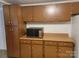 Functional kitchen featuring wooden cabinets, ample counter space, and modern microwave at 7597 Webbs Rd, Denver, NC 28037
