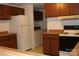 Functional kitchen featuring wood cabinets, a white refrigerator, and essential appliances at 7597 Webbs Rd, Denver, NC 28037