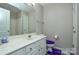 Bright bathroom featuring a single sink vanity, white cabinets, a toilet and a large mirror at 8364 Chaceview Ct, Charlotte, NC 28269