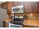Modern kitchen with stainless steel appliances, granite countertops, and tile backsplash at 8364 Chaceview Ct, Charlotte, NC 28269