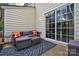 Cozy outdoor patio space with comfortable wicker seating, a glass table, and a sliding glass door entrance at 8364 Chaceview Ct, Charlotte, NC 28269