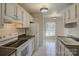 Well-lit kitchen featuring white cabinets, black countertops, and modern appliances at 961 Sardis Cove Dr, Charlotte, NC 28270