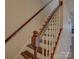 Staircase with wooden handrail, white spindles, and stained treads at 961 Sardis Cove Dr, Charlotte, NC 28270