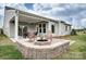 Inviting outdoor space with a stone fire pit, covered patio, dining area, and rocking chairs for relaxing at 1018 Heritage Pointe # 302, Indian Trail, NC 28079