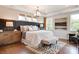 Beautiful bedroom featuring a padded headboard, bench, a modern chandelier and hardwood flooring at 1018 Heritage Pointe # 302, Indian Trail, NC 28079
