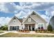 Charming single-Gathering home with stone accents, neutral siding, manicured lawn, and inviting, covered entryway at 1018 Heritage Pointe # 302, Indian Trail, NC 28079