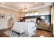 Cozy main bedroom with tray ceiling, padded headboard, and view into the modernly-tiled bathroom at 1018 Heritage Pointe # 302, Indian Trail, NC 28079