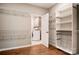 Walk-in closet with custom shelving leading to a utility room with a white washer and dryer at 1018 Heritage Pointe # 302, Indian Trail, NC 28079