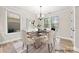 A virtually staged dining room features a table set for six with a view of the backyard at 110 Kingsdown Ave, Charlotte, NC 28270