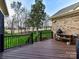 Inviting outdoor patio with cooking area, wood floors and black railing overlooking a scenic backyard at 1110 Woodhall Dr, Huntersville, NC 28078