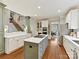 Modern kitchen with white cabinets, center island, stainless steel appliances, and an adjacent staircase at 1110 Woodhall Dr, Huntersville, NC 28078