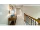 Upstairs hallway with wood railing, console table, lamp, and carpeted floor at 121 Asmodean Ln, Troutman, NC 28166