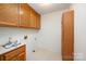 A laundry room with overhead cabinets, a utility sink and faucet, and space for a washer and dryer at 126 Harbourtown Dr, Kings Mountain, NC 28086