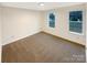 Cozy bedroom with neutral carpet, white walls, and natural light from two windows at 1313 Ridgewood Dr, Concord, NC 28027