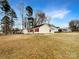 Single-Gathering home featuring red shutters, a fenced yard, and mature trees at 1313 Ridgewood Dr, Concord, NC 28027