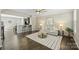 Bright living room featuring hardwood floors, modern lighting, and an open floor plan with sight lines to the kitchen at 1317 Queen Lyon Ct, Charlotte, NC 28205