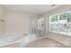 Bathroom featuring a glass shower stall, corner bathtub, and a bright window at 1615 Jekyll Ln, Waxhaw, NC 28173
