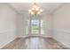 Elegant dining room with wainscoting, modern floors, and a bay window at 1615 Jekyll Ln, Waxhaw, NC 28173