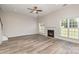 Living room with modern fireplace, ceiling fan, and light-toned hardwood floors at 1615 Jekyll Ln, Waxhaw, NC 28173