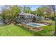 Resort style backyard includes a stone patio, pristine pool, and well-manicured lawn with a view at 19528 Mary Ardrey Cir, Cornelius, NC 28031