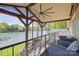 Outdoor deck overlooking the lake with comfortable seating and a ceiling fan at 19528 Mary Ardrey Cir, Cornelius, NC 28031