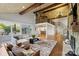 Bright and airy living room featuring wood beams, stone fireplace, and seamless access to the deck at 19528 Mary Ardrey Cir, Cornelius, NC 28031