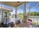 Covered deck with hot tub and lake views, framed by stone columns and wrought iron railing at 19528 Mary Ardrey Cir, Cornelius, NC 28031