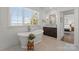 Stylish bathroom with soaking tub, large window, and vanity with a marble countertop at 20637 Island Forest Dr, Cornelius, NC 28031