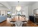 Elegant dining area with a long wooden table, modern chandelier, and a view of the kitchen at 20637 Island Forest Dr, Cornelius, NC 28031