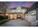 Beautiful two-story home with white brick and a three-car garage, captured at twilight at 20637 Island Forest Dr, Cornelius, NC 28031
