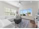 Sunlit living room featuring large windows with lake views, modern furniture, and plush rug at 20637 Island Forest Dr, Cornelius, NC 28031