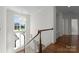 Staircase with wooden handrail and large bright window overlooking front yard at 20637 Island Forest Dr, Cornelius, NC 28031