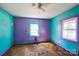 Turquoise and purple bedroom featuring a ceiling fan, window and damaged floors at 208 Columbia Ave, Rock Hill, SC 29730