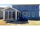Back view of blue two-story home featuring a sun room and neutral lawn at 2085 Saddlebred Dr, Iron Station, NC 28080