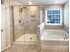 Bathroom featuring a glass enclosed shower, soaking tub, and ceramic tile at 2085 Saddlebred Dr, Iron Station, NC 28080