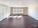 Large bright bedroom with dark hardwood floors, neutral walls, and three sunny windows at 2085 Saddlebred Dr, Iron Station, NC 28080
