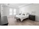 Spacious bedroom with a bed, bench, bedside tables, and sleek hardwood floors at 218 Alenda Lux Cir, Mooresville, NC 28115