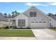 Charming home featuring gray siding, a two-car garage, well-manicured lawn and a sidewalk at 218 Alenda Lux Cir, Mooresville, NC 28115