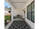 Inviting covered front porch featuring a bench, stylish rug, and black trimmed windows at 218 Alenda Lux Cir, Mooresville, NC 28115