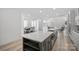 Open-concept kitchen with a large island, stainless steel sink, and view of the dining and living areas at 218 Alenda Lux Cir, Mooresville, NC 28115
