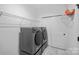 Functional laundry room with modern washer and dryer, storage shelves, and closet at 218 Alenda Lux Cir, Mooresville, NC 28115