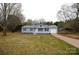 Charming single-story home featuring a light blue exterior, well-maintained landscaping, and a covered parking area at 2225 Grace Church Rd, Salisbury, NC 28147